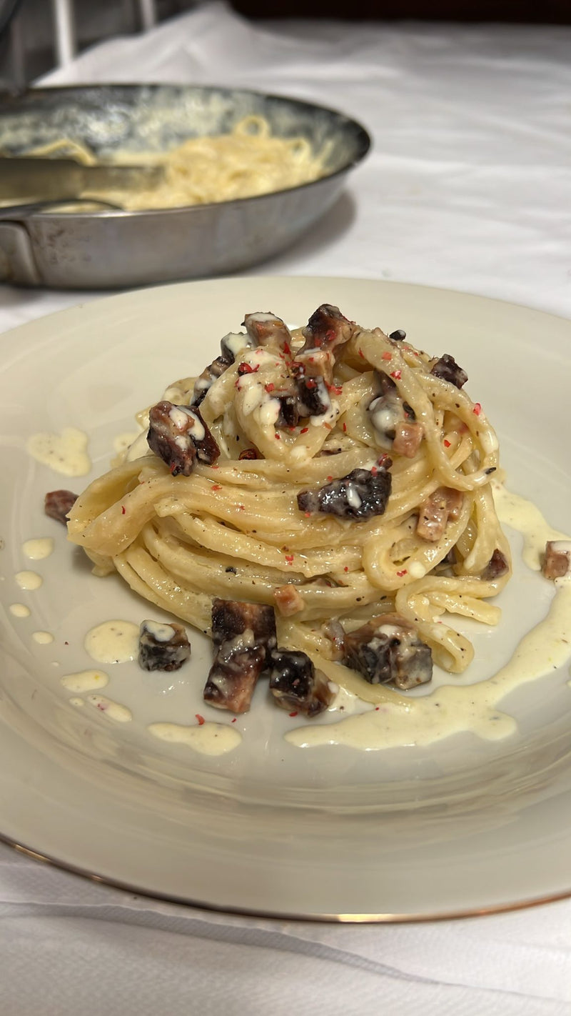 A comforting plate of plant-based spaghetti carbonara made with a creamy sauce and crispy Anna Meru Alpine Smoked Vegan Cubes.